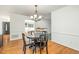 Inviting dining area featuring hardwood floors and a stylish light fixture, adjacent to living spaces at 1224 Manchester Dr, Raleigh, NC 27609