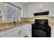 Well-lit kitchen featuring modern sink, granite countertops, and classic white cabinetry at 1403 Fairground Road Rd, Dunn, NC 28334