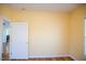 Bedroom features hardwood floors and yellow walls, with an open door to another room at 159 Valhalla Dr, Timberlake, NC 27583