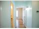 Hallway view with neutral paint, leading to another room with hardwood floors at 159 Valhalla Dr, Timberlake, NC 27583