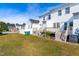 Backyard of a two-story townhouse with green grass and a wooden deck at 1707 Stroll Cir, Fuquay Varina, NC 27526