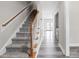 Inviting hallway with hardwood floors leading to a carpeted staircase at 1707 Stroll Cir, Fuquay Varina, NC 27526