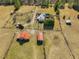 Stunning aerial view of the property displaying large yard with outbuildings, gardens and mature trees at 1834 Dewitt Smith Rd, Pittsboro, NC 27312