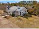 Aerial view of the white brick house with a metal roof, surrounded by trees and landscaping at 1834 Dewitt Smith Rd, Pittsboro, NC 27312