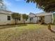 Spacious backyard with a well-maintained lawn, white brick home, and mature trees at 1834 Dewitt Smith Rd, Pittsboro, NC 27312