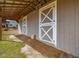 Exterior side view of a horse barn featuring gray siding, white trim, and enclosed stalls at 1834 Dewitt Smith Rd, Pittsboro, NC 27312