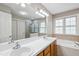 Bright bathroom with double sinks, soaking tub, and separate glass shower at 2006 Chedington Dr, Apex, NC 27502