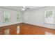 Spacious bedroom with hardwood floors, a ceiling fan, and three large windows allowing lots of natural light at 2006 Chedington Dr, Apex, NC 27502