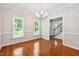 Elegant dining room featuring hardwood floors, natural light from the windows, and a modern chandelier at 2006 Chedington Dr, Apex, NC 27502