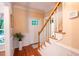 Bright foyer featuring hardwood floors, paneled wainscoting, white staircase, and a decorative glass paneled front door at 2006 Chedington Dr, Apex, NC 27502