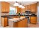 Well-equipped kitchen featuring stainless steel appliances, granite countertops, wooden cabinets, and a center island at 2006 Chedington Dr, Apex, NC 27502