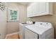 Convenient laundry room with modern white washer and dryer and overhead cabinets at 2006 Chedington Dr, Apex, NC 27502