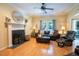 Cozy living room with hardwood floors, a fireplace with a white mantel, and comfortable leather seating at 2006 Chedington Dr, Apex, NC 27502