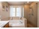 Relaxing main bathroom featuring a soaking tub, separate glass-enclosed shower, and a neutral color palette at 2006 Chedington Dr, Apex, NC 27502