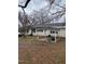 Backyard view of a white home with a small pergola covered patio with ample yard space at 2009 Windy Hill Farm Ln, Zebulon, NC 27597
