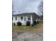 Exterior view of a charming home with light colored siding and simple landscaping at 2009 Windy Hill Farm Ln, Zebulon, NC 27597