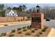 Brick community sign with a black 'Bentwinds Bluffs' sign surrounded by landscaping and a new home in background at 2300 Eagle Shot Ct # 25, Fuquay Varina, NC 27526