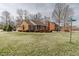 Traditional brick home with manicured lawn, shuttered windows, and covered front porch at 2504 Churchill Dr, Burlington, NC 27215