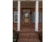 Welcoming brick front porch with brick steps, columns, stained glass door, and blue shutters at 2504 Churchill Dr, Burlington, NC 27215