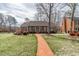 Charming single-story brick home with a well-manicured lawn and a red brick walkway at 2504 Churchill Dr, Burlington, NC 27215