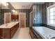 Luxurious main bathroom with soaking tub, double vanity, and decorative wallpaper at 2504 Churchill Dr, Burlington, NC 27215
