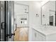 Bathroom featuring white cabinets and countertops, a large mirror, and an open doorway to the living area at 2728 Milburnie Rd, Raleigh, NC 27610