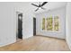 Bright bedroom with hardwood floors, a modern ceiling fan, and a large window overlooking the greenery at 2728 Milburnie Rd, Raleigh, NC 27610