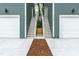 Modern townhome exterior featuring private garages and exterior stairs leading to the entry door at 2728 Milburnie Rd, Raleigh, NC 27610