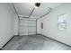 Clean and bright garage with a concrete floor, window, and a new white garage door at 2728 Milburnie Rd, Raleigh, NC 27610