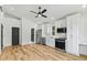 Open-concept kitchen with stainless steel appliances, white cabinets, hardwood floors, and modern lighting at 2728 Milburnie Rd, Raleigh, NC 27610