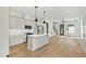Open-concept kitchen with white cabinets, stainless steel appliances, and an island with quartz countertop at 2728 Milburnie Rd, Raleigh, NC 27610