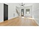 Open-concept living room with modern black door, wooden flooring, and a staircase at 2728 Milburnie Rd, Raleigh, NC 27610