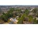 An aerial view of a bright home surrounded by lush trees with a city skyline in the background at 2730 Milburnie Rd, Raleigh, NC 27610