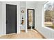 Bright entryway with a built-in shelving unit, a modern black door, and a large window at 2730 Milburnie Rd, Raleigh, NC 27610