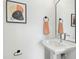 Well-lit powder room features a pedestal sink, decorative mirror, and stylish hardware at 2730 Milburnie Rd, Raleigh, NC 27610