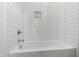 Clean shower and tub combo with white tiled walls and a recessed niche for storage at 2730 Milburnie Rd, Raleigh, NC 27610