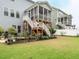 Backyard view featuring stairs to a porch, seating, landscaping, and grass at 286 Two Creeks Lp, Chapel Hill, NC 27517