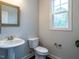 Cozy powder room features a pedestal sink, a toilet, and a window with natural light at 286 Two Creeks Lp, Chapel Hill, NC 27517