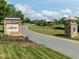 Community entrance area featuring a sign, landscaping, and a street with green space at 286 Two Creeks Lp, Chapel Hill, NC 27517