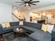 Spacious living room with comfortable gray sectional, modern fan and view into kitchen at 286 Two Creeks Lp, Chapel Hill, NC 27517