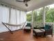 Covered porch area with seating, a hammock, wood floors and views of the trees at 286 Two Creeks Lp, Chapel Hill, NC 27517