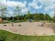 Community playground with a seesaw and slide surrounded by lush greenery at 286 Two Creeks Lp, Chapel Hill, NC 27517