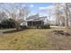 Expansive backyard showcasing a screened porch, lush lawn, and rustic stone fire pit for outdoor enjoyment at 2905 Whitehart Ln, Raleigh, NC 27606