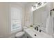 Stylish half bathroom with modern fixtures, a framed mirror and a bright window at 2905 Whitehart Ln, Raleigh, NC 27606
