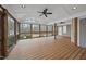 Enclosed porch featuring wood floors, wood beams, a ceiling fan, and views of trees at 2905 Whitehart Ln, Raleigh, NC 27606