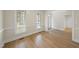 Open room with wood floors, two windows with blinds, and white trim at 2905 Whitehart Ln, Raleigh, NC 27606