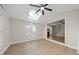 Inviting sunroom with skylight, fan, and hardwood floors next to living room with fireplace at 2905 Whitehart Ln, Raleigh, NC 27606
