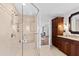 Bathroom featuring a glass enclosed shower, marble tile and dark wood cabinets at 303 Laurel Hill Road, Chapel Hill, NC 27514