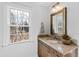 Bright bathroom featuring a granite countertop vanity and a large window for natural light at 303 Laurel Hill Road, Chapel Hill, NC 27514