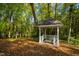 Secluded gazebo in a leafy forest offers a tranquil retreat for quiet contemplation amid natural beauty at 303 Laurel Hill Road, Chapel Hill, NC 27514